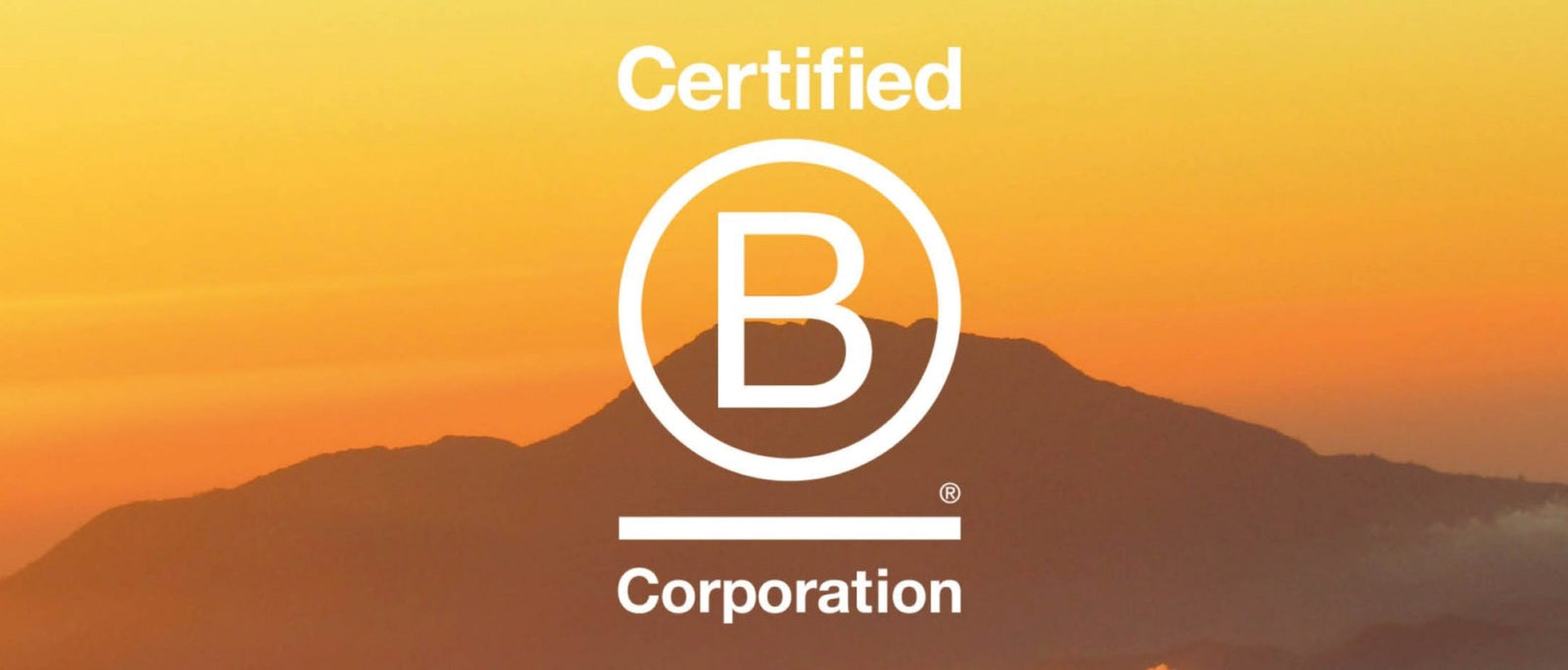 An orange Dark Energy Poseidon power bank resting on a topographic map inside a tent, with snow-capped mountains outside