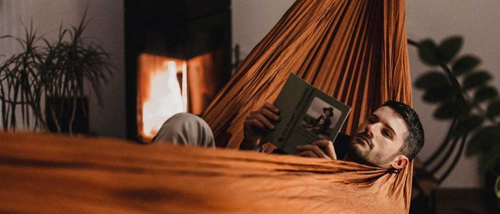 An orange Dark Energy Poseidon power bank resting on a topographic map inside a tent, with snow-capped mountains outside