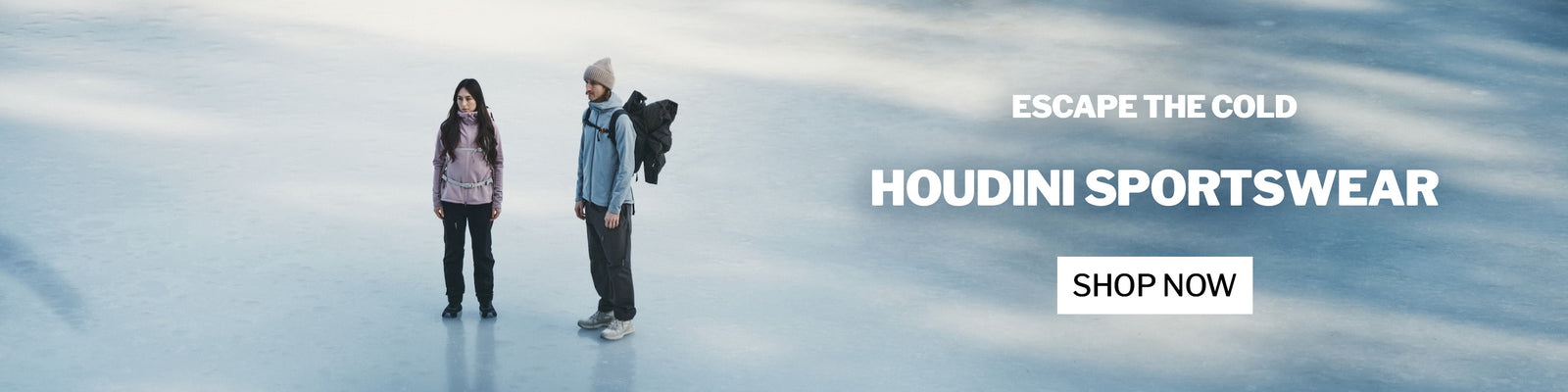 Two people in winter clothing on a frozen lake with 'Escape the Cold Houdini Sportswear Shop Now' text overlay.