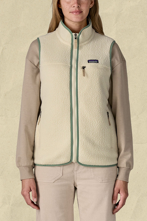 Woman wearing a cream fleece gilet with sage green trim and zip fastening over a beige long-sleeved top.