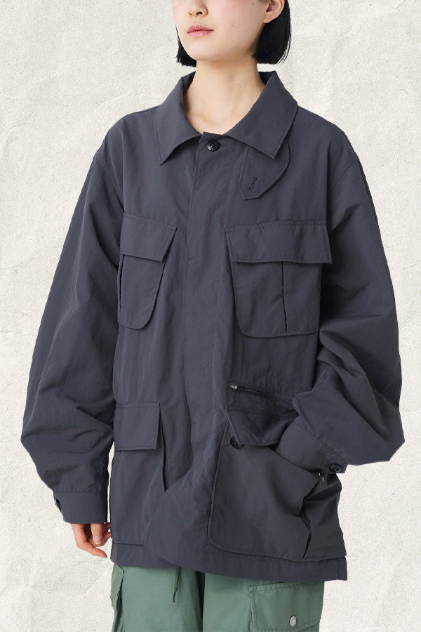 Woman wearing a dark grey oversized cargo jacket with multiple pockets and a collar.