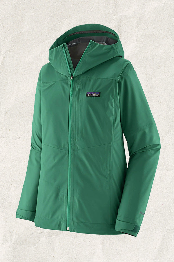 Patagonia women's green waterproof rain jacket with hood against a neutral background.