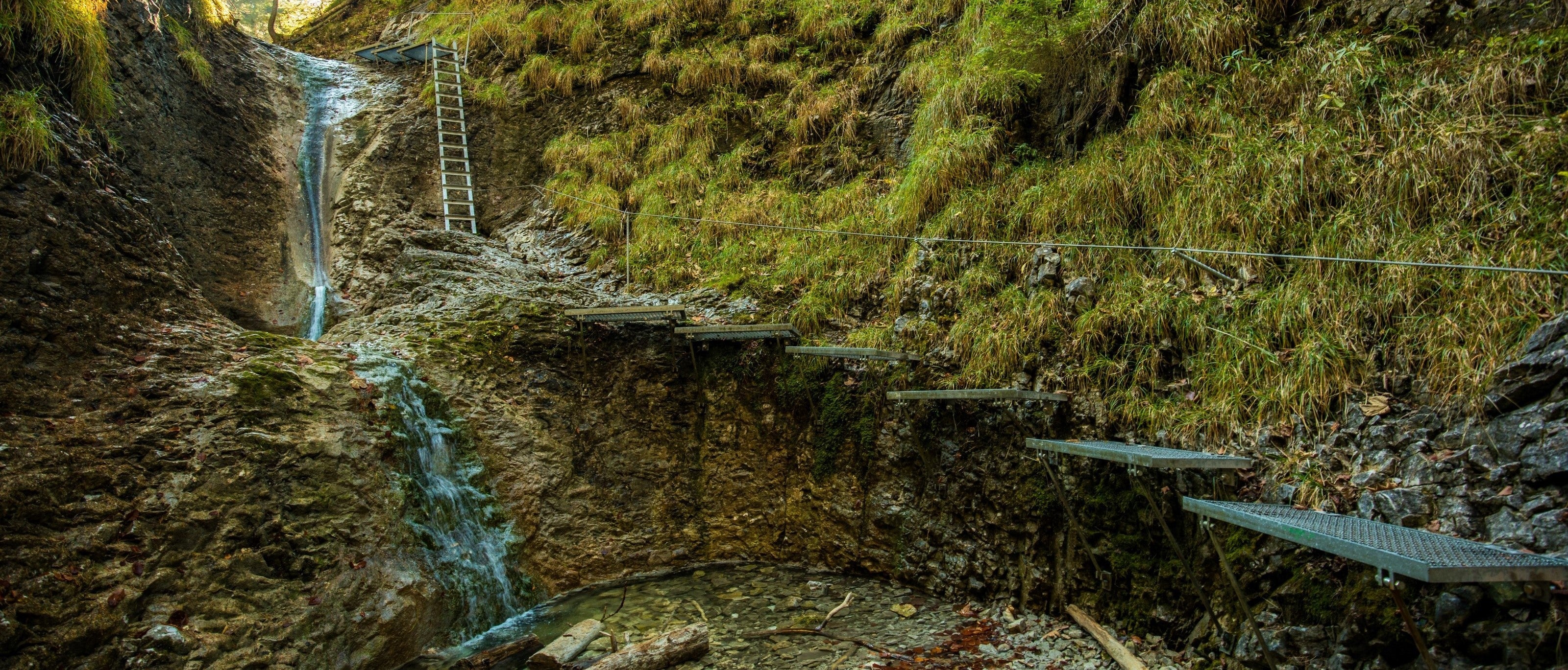 narrow gorge with river flowing through the middle, a small path runs along the side